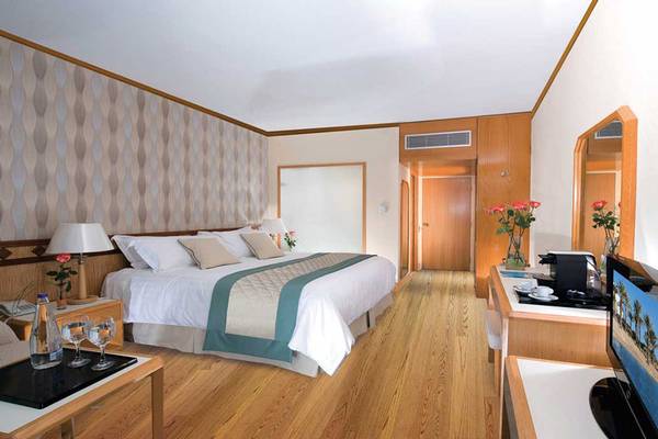 Ein modernes Schlafzimmer im Pioneer Beach Hotel mit einem großen Bett, Nachttischen und einem Fernseher.
