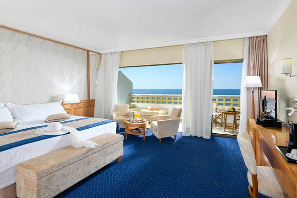 Zimmer im Pioneer Beach Hotel mit Blick auf das Meer und eine Terrasse.