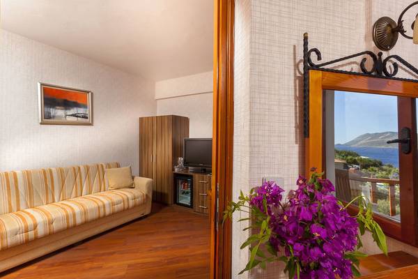 Innenansicht des Cappari Hotels Aquarius, Wohnbereich mit Sofa, Fernseher und Meerblick.