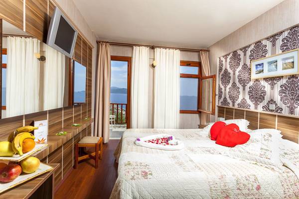 Doppelzimmer im Cappari Hotels Aquarius mit zwei Betten, Früchten und einem Meerblick.