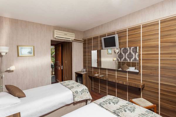 Doppelzimmer im Cappari Hotels Aquarius mit zwei Betten, Fernseher und Spiegel