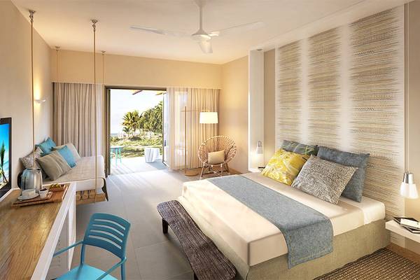 Schlafzimmer im Anelia Resort & Spa mit großem Bett, Sofa, Schreibtisch, Fernseher und Balkon