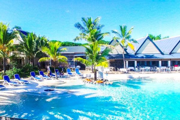 Poolbereich des Anelia Resort & Spa mit Lounge-Sesseln und Palmen.