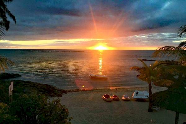 Sonnenuntergang am Strand des Anelia Resort & Spa mit Booten und Palmen