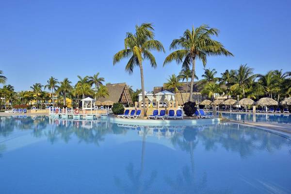 Poolbereich des Melia Las Antillas Hotels mit blauen Liegestühlen und Palmen