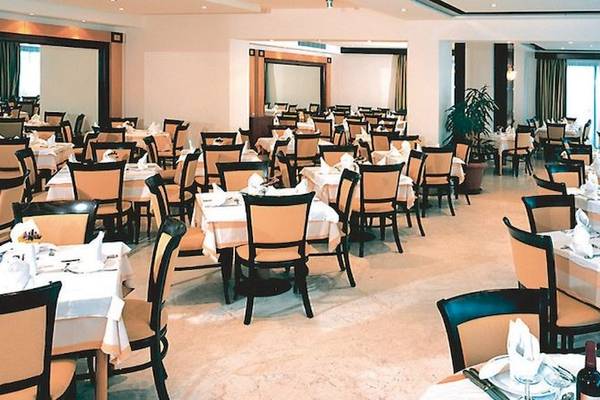 Innenansicht des Restaurants im Calypso Palace Hotel mit gedeckten Tischen und Stühlen.