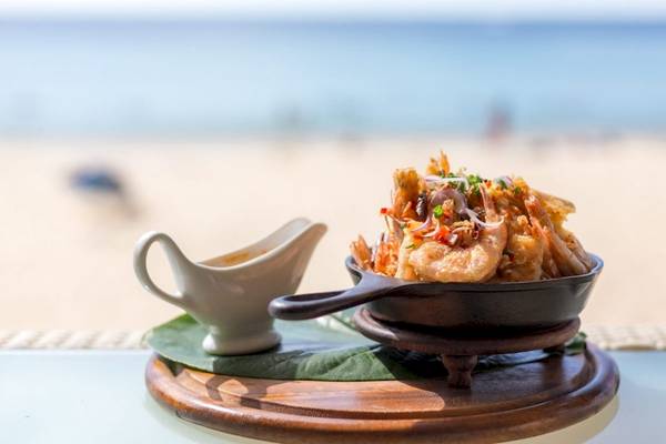 Ein Gericht auf einem Teller am Strand im Beyond Resort Khao Lak.