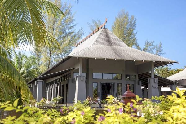 Außenansicht des Beyond Resort Khao Lak, umgeben von tropischen Pflanzen und Bäumen.