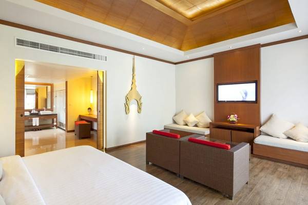 Luxuriöse Hotelsuite im Beyond Resort Khao Lak mit Doppelbett, Wohnzimmerbereich und Flachbildfernseher.