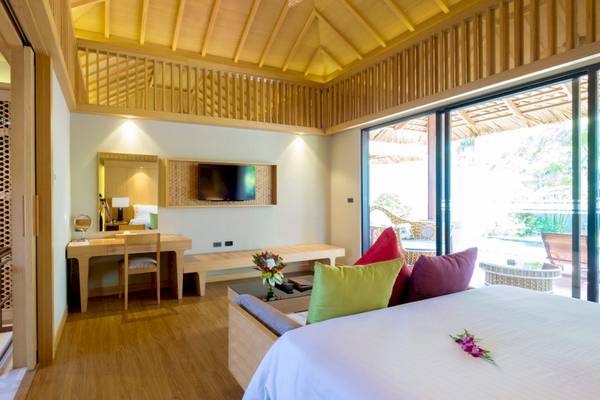 Innenansicht eines Hotelzimmers im Beyond Resort Khao Lak mit modernem Design, hellem Holz und offenen Glastüren.