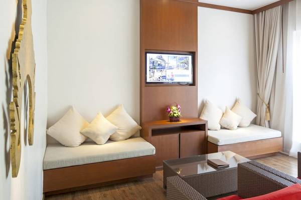 Inneneinrichtung eines Zimmers im Beyond Resort Khao Lak mit Sofas, Kissen, Fernseher und Tisch