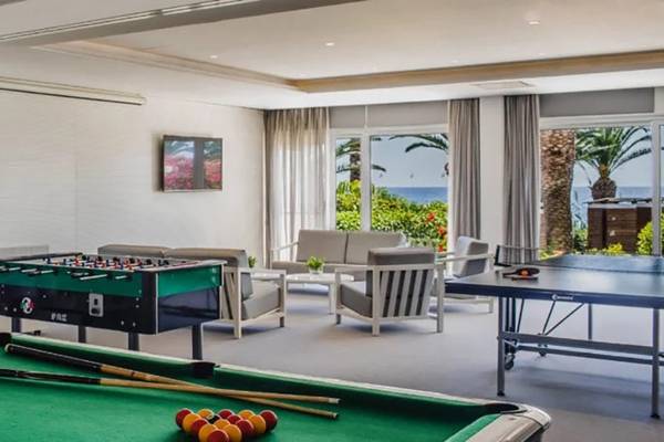 Spielzimmer im Alion Beach Hotel mit Billardtisch, Tischtennisplatte und Sofas.
