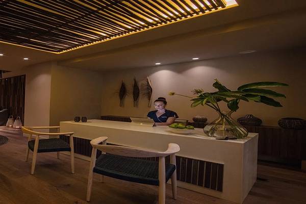 Lobby-Lounge des Alion Beach Hotels mit Sitzbereich, Empfangstresen und Pflanzendekor.