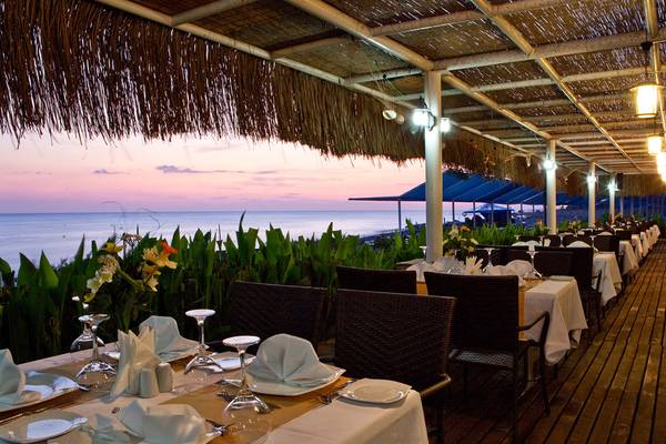 Abendessen auf der Terrasse im Crystal Admiral Resort mit Blick auf das Meer und gedeckten Tischen.