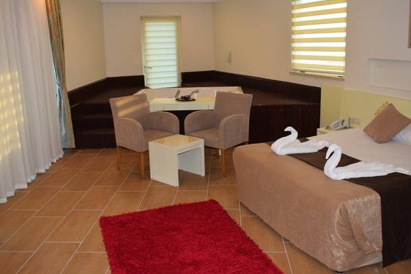 Hotelzimmer des Crystal Admiral Resort Suites & Spa mit Badewanne, Sesseln und Bett.