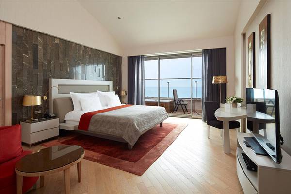 Suite-Zimmer im Maxx Royal Belek Golf Resort mit Meerblick, modernem Interieur und bequemem Bett.