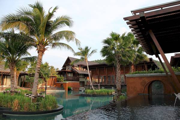 Außenbereich des Mai Samui Beach Resort mit Swimmingpool, Palmen und Gebäuden.