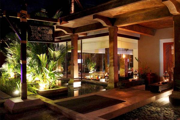 Außenbereich des Mai Samui Beach Resort & Spa bei Nacht mit Beleuchtung und Pflanzen.