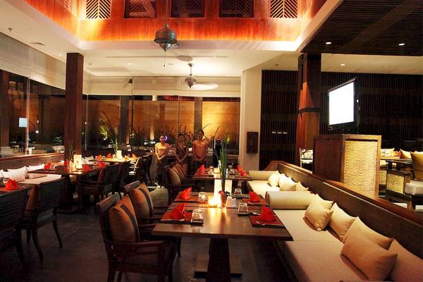 Innenbereich des Restaurants im Mai Samui Beach Resort & Spa mit gedeckten Tischen und stehenden Gästen.