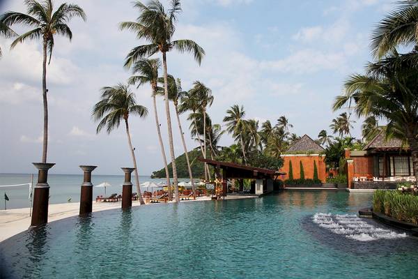 Außenpool des Mai Samui Beach Resort & Spa mit Palmen und Sonnenliegen
