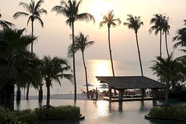 Sonnenuntergang am Strand des Mai Samui Beach Resorts mit Palmen und Wasserbar