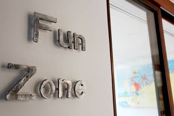Das Schild mit dem Wort 'Fun Zone' ist an einer Wand befestigt.