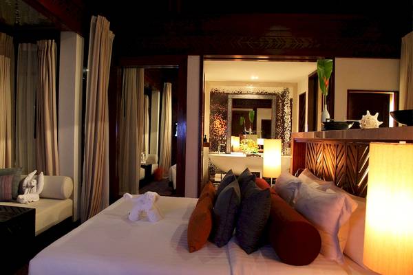 Schlafzimmer im Mai Samui Beach Resort & Spa mit einem Doppelbett und Dekorelementen.