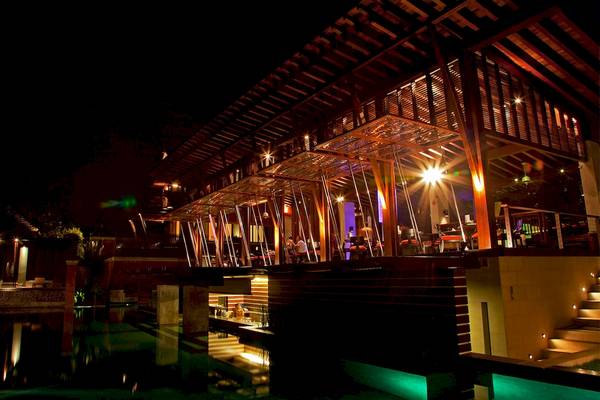 Nachtansicht des Mai Samui Beach Resort & Spa mit beleuchteter Terrasse und Pool.