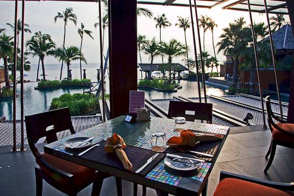 Außenterrasse mit Tisch und Blick auf den Pool im Mai Samui Beach Resort.