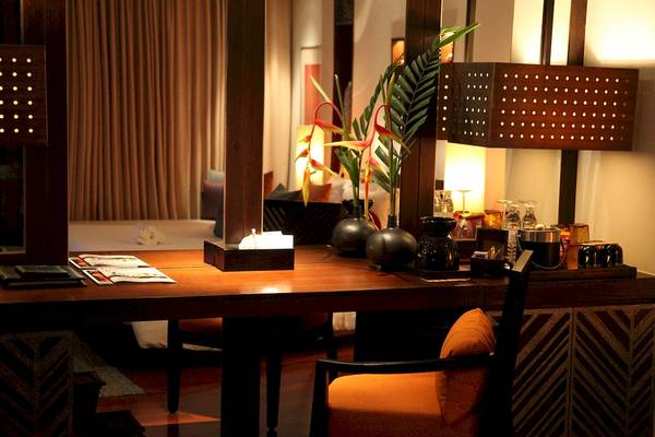 Hotelzimmer mit Schreibtisch, Kissen und Pflanzendekor