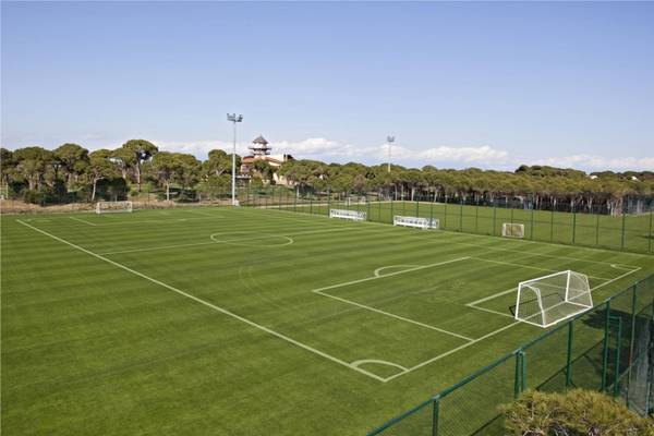 Fußballplatz im Maxx Royal Belek Golf Resort mit leerem Spielfeld, markierten Linien und Toren.
