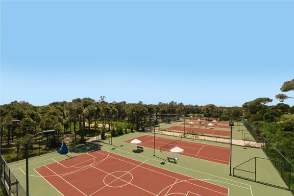 Tennisplätze im Maxx Royal Belek Golf Resort, umgeben von Bäumen und Schatten.