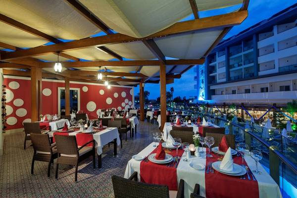 Außenbereich des Seashell Resort & Spa mit gekleideten Tischen und rot-weißen Wandmustern.