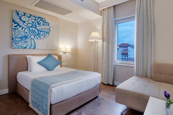 Hotelzimmer im Seashell Resort & Spa mit Bett, Sofa und Fensterblick auf ein Gebäude.