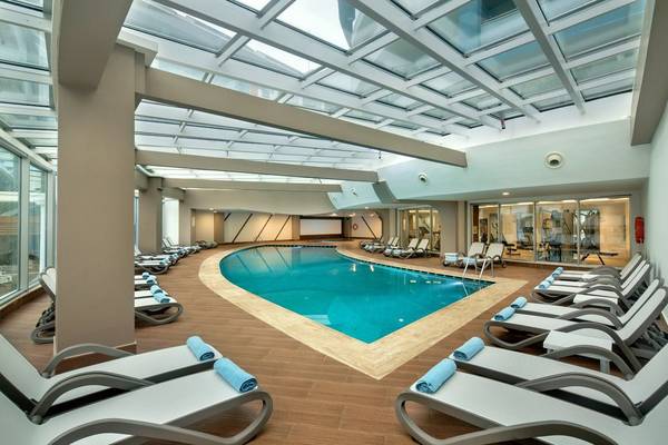 Innenpool des Seashell Resort & Spa mit umliegenden weißen Liegen und blauen Handtüchern.