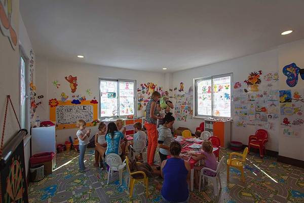 Kinderspielzimmer im Seashell Resort & Spa mit bunten Wandaufklebern und Tischen