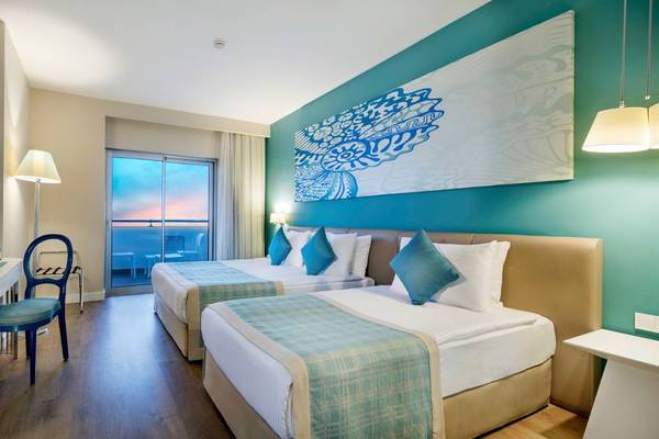 Zwei Betten in einem eleganten Hotelzimmer des Seashell Resort & Spa mit moderner Einrichtung und Aussicht.