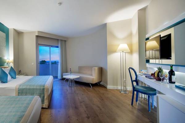Hotelzimmer im Seashell Resort & Spa mit zwei Betten, einem Sofa und einer Terrasse.