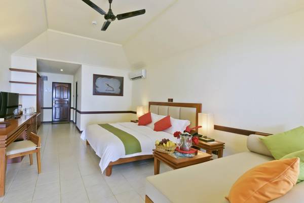 Innenansicht eines Hotelzimmers im Villa Nautica Paradise Island Resort mit einem Bett, Schreibtisch und Sofa.