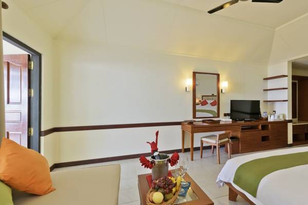 Innenansicht eines Hotelzimmers der Villa Nautica Paradise Island Resort mit zwei Betten, Schreibtisch, Fernseher und Obstkorb.