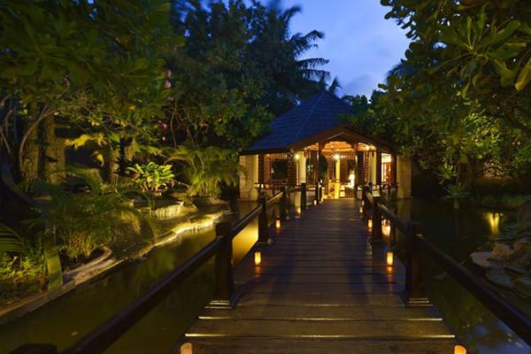 Villa Nautica Paradise Island Resort Eingang mit hölzerner Brücke und Kerzenbeleuchtung