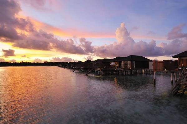 Sonnenuntergang am Villa Nautica Paradise Island Resort mit Wasservillen und leuchtendem Himmel