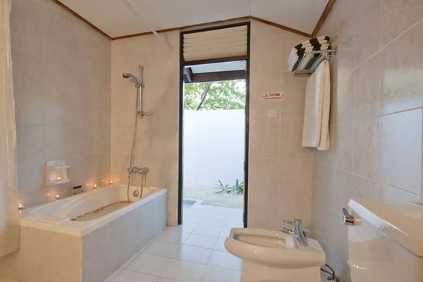 Badezimmer im Villa Nautica Paradise Island Resort mit Badewanne, Dusche und Toilette.