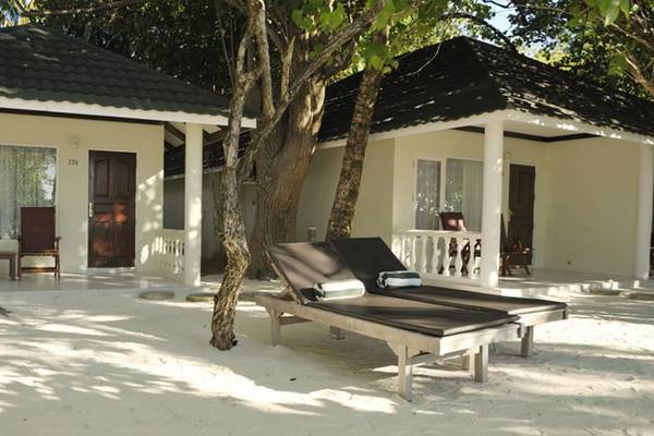 Außenbereich des Villa Nautica Paradise Island Resorts mit zwei weißen Hütten und Liegestühlen im Sand.