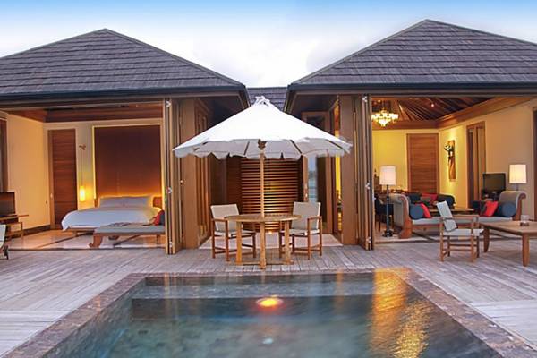 Außenbereich des Villa Nautica Paradise Island Resorts mit Pool, Sonnenschirm, Tisch und Stühlen.