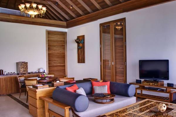Wohnbereich der Villa Nautica Paradise Island Resort mit Sofa, Fernseher und Holzmöbeln.