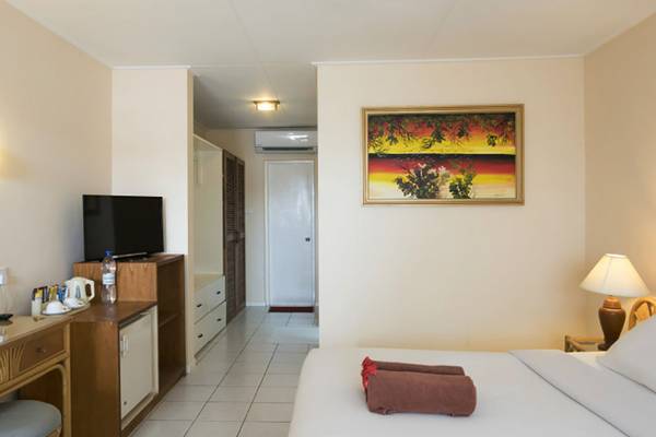 Hotelzimmer im Villa Nautica Paradise Island Resort mit Fernseher, Schreibtisch, Lampe und Gemälde an der Wand.