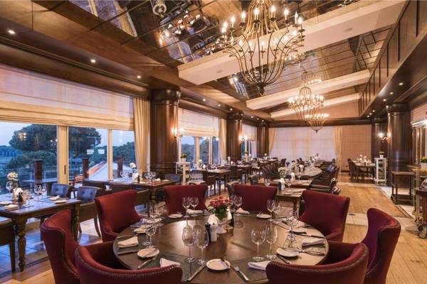 Innenbereich des Restaurants im Maxx Royal Belek Golf Resort mit eleganten Tischstühlen und kristallenen Kronleuchtern.