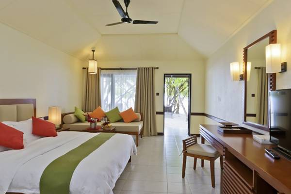 Villa Nautica Paradise Island Resort Hotelzimmer mit Bett, Sofa, Fernseher und Schreibtisch.