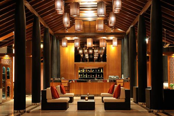 Loungebereich im Villa Nautica Paradise Island Resort mit gemütlichen Sitzmöbeln, schwarzen Säulen und warmen Lichtern.